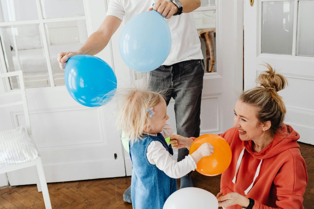 Eine glückliche Familie genießt spielerische Momente der Verbundenheit mit bunten Luftballons im Haus.